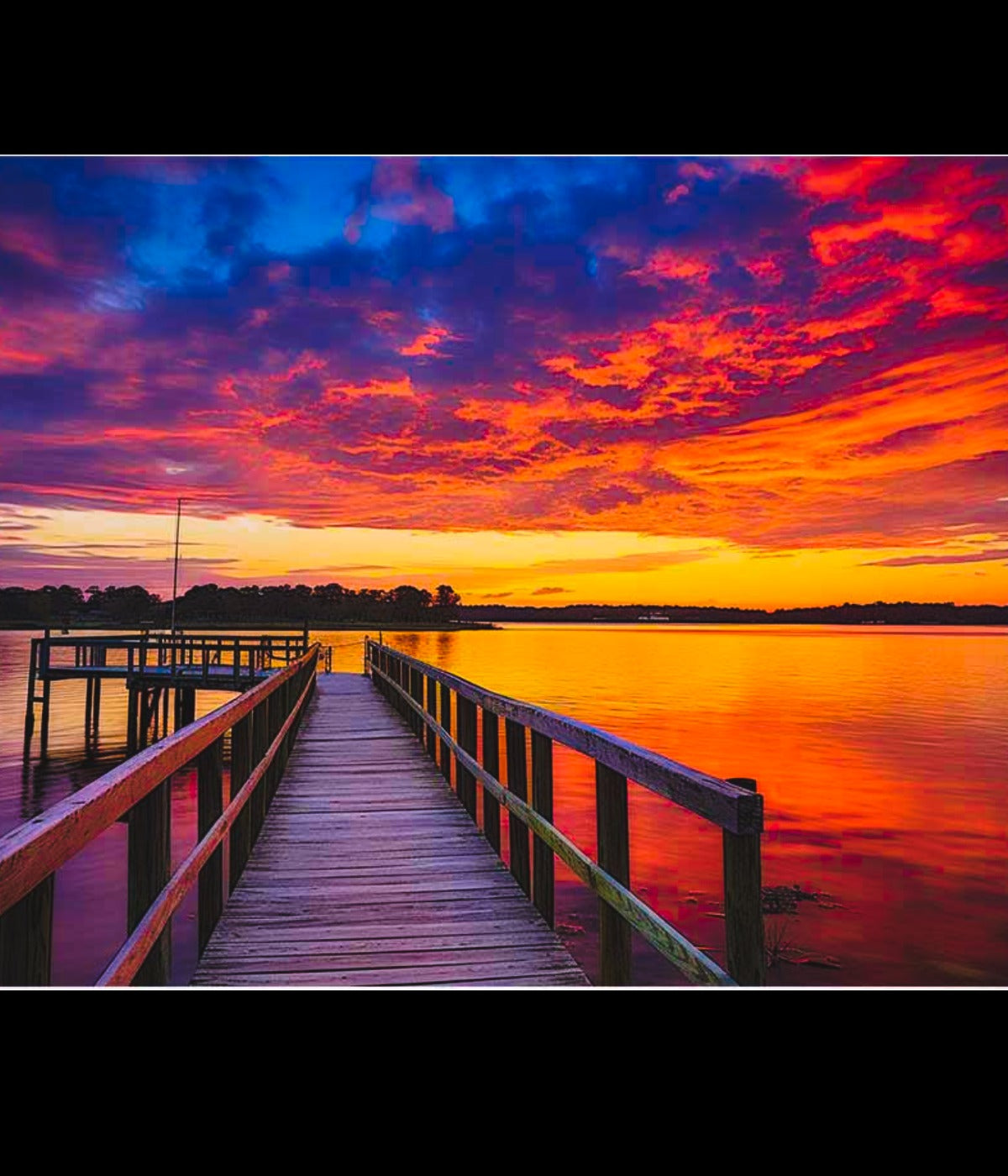 Vibrant jetty sunset over calm lake with wooden dock, perfect for coastal canvas wall art décor.