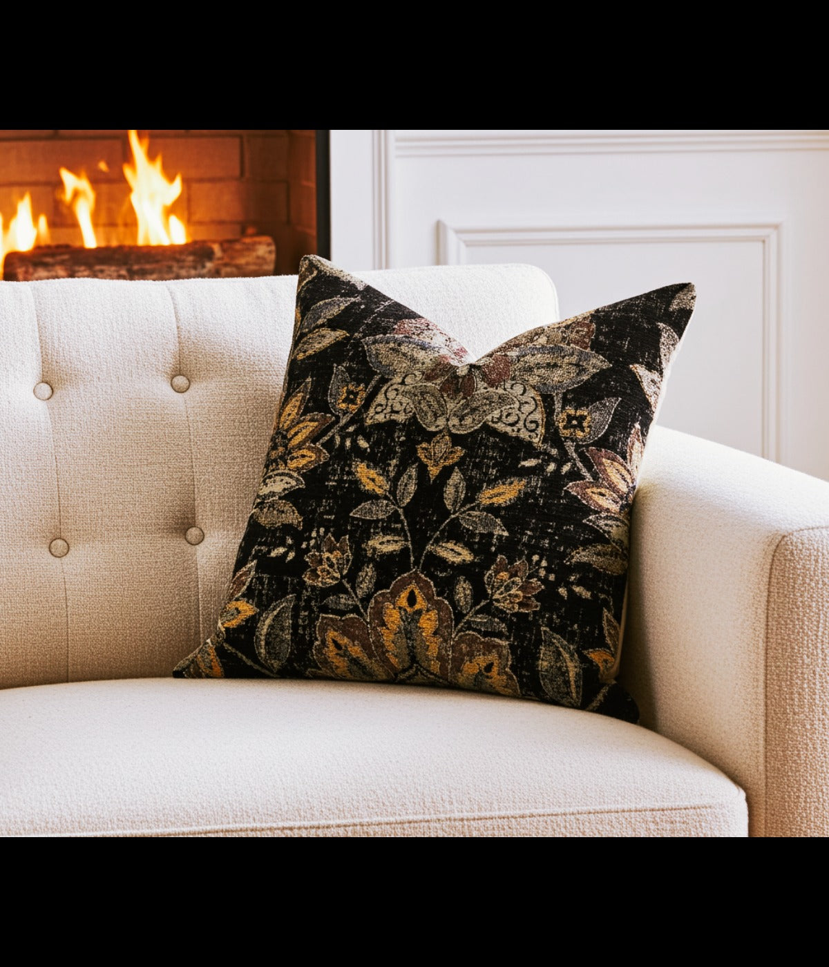 Noir lotus blossom luxury throw pillow styled on a beige sofa in front of a warm fireplace.